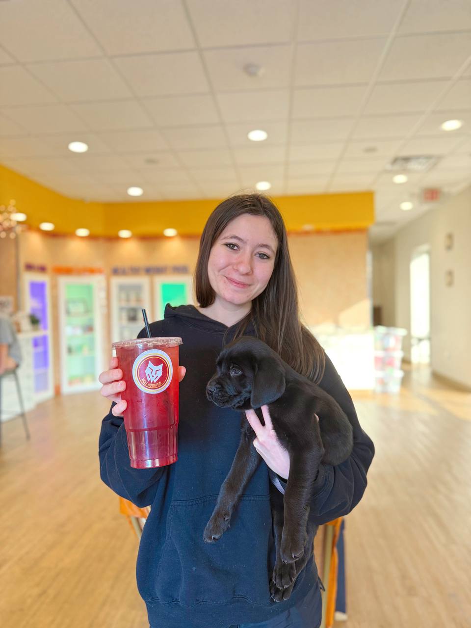 Wolf Nutrition customer with a black puppy and red tea